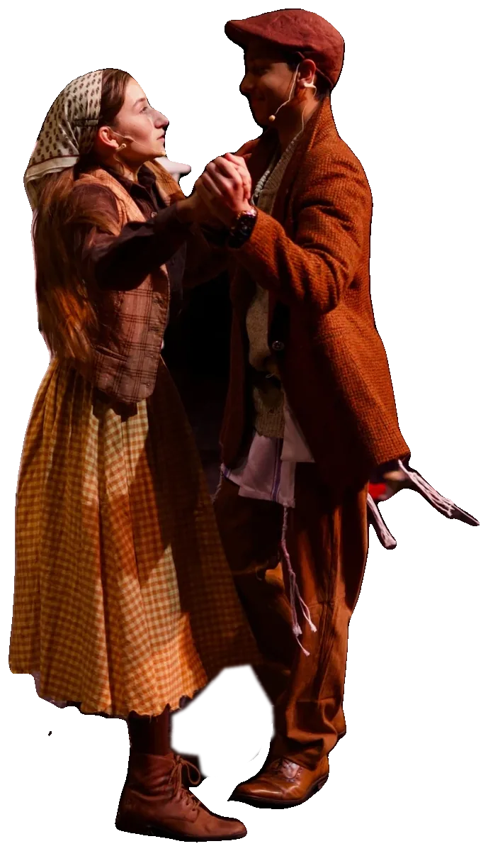 A young couple in period costume dance close together, hands joined, smiling at each other.